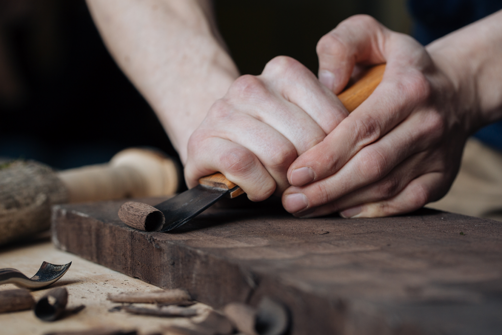 Foto di piani in legno vecchio stile con scalpelli da intaglio posati su  banco da lavoro con scultura in legno a bassorilievo a drago Foto stock -  Alamy